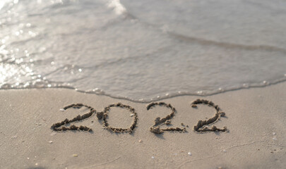 The numbers 2022 are washed away by the sea waves of the Persian Gulf. The concept of a change of years