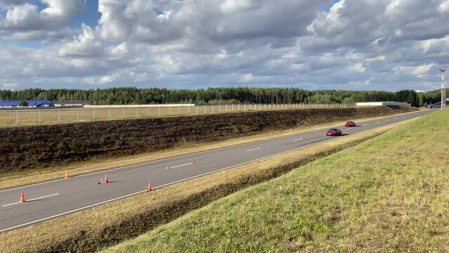 Drag racing, racing cars compete in 402 meters. Arrivals of cars on a straight asphalt race track. Race cars during races. Sports car for a race on the track. Electric car competes in drag racing.