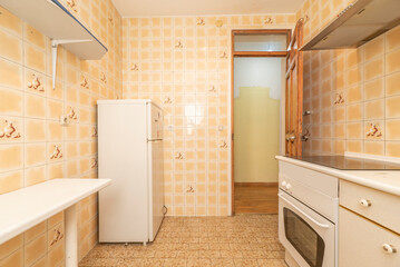 Old apartment kitchen with white cabinets, corner fridge and white claw top