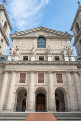 Facades of the monastery of El Escorial in Madrid on a day of blue skies with white clouds with statues of different historical kings