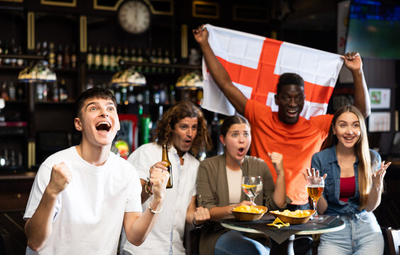 International group of people with England flag toasting with beer, having fun at party in nightclub