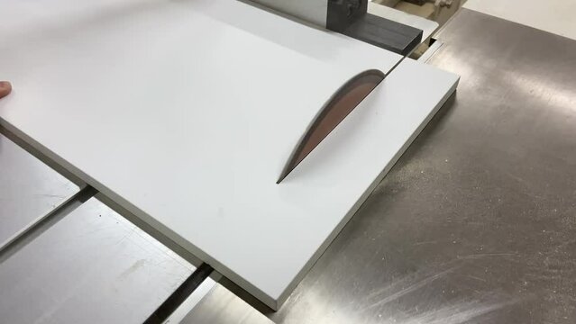 Circular saw for cutting wooden panel made of fiberboard in workshop. Carpenter equipment for Medium Density Fiberboard (MDF) processing. Woodworking machine with a electric circular saw. Woodworking
