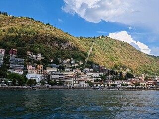 Fototapeta na wymiar Lake Como country on a summer sunny day. View of the bay. Lake Como and mountains. Scenic view of the resort town. Beautiful Italian landscape.