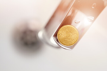 Twenty cent coin on a bathroom faucet. Economical water consumption idea