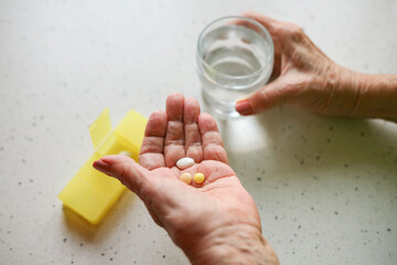 Fototapeta Taking medication - close-up of an elderly person's hand with pills obraz