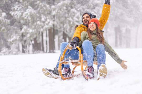 Couple having fun sledging while on winter vacation
