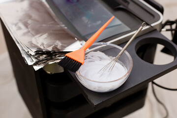 Hairdressing set with hair dye, foil and brush on the table in the barber shop