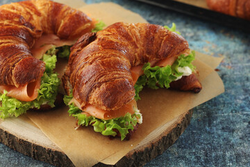 Freshly baked croissants with salmon and salad on the table