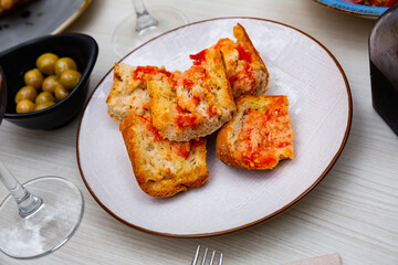 Appetizing Pan con tomate - grilled bread topped with mixture of grated tomatoes with salt and olive oil. Popular Catalan wine tapas.