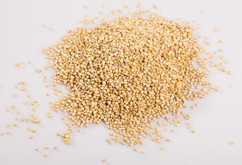 Heap of raw seeds of quinoa on white surface. Healthy nutrition..