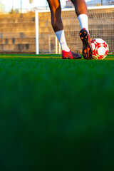 Football player feet running with the ball in front of the field. Player feet with the ball scoring a goal. Football player on the field running with the ball © Ivi - Powerlightss