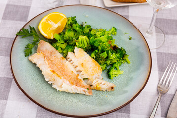 Baked red perch fillet served with seared broccoli, lemon and parsley