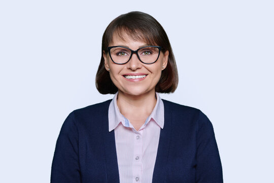 Portrait of business smiling woman looking at camera, white background