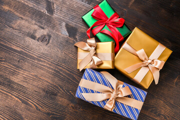 Fototapeta premium gift wrapping Festive christmas new year background colorful gift boxes and holiday decorations on wood background. New Year's present and Christmas present top view 