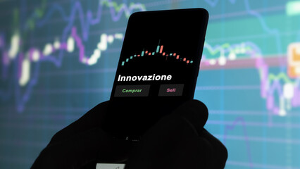 Un inversor está analizando el innovazione etf fondo en pantalla. Un teléfono muestra los precios...