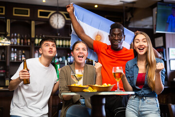 Joyful fans of the Argentina team celebrating the victory in the night bar