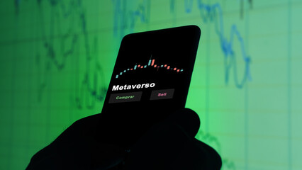 Un inversor está analizando el metaverso etf fondo en pantalla. Un teléfono muestra los precios...