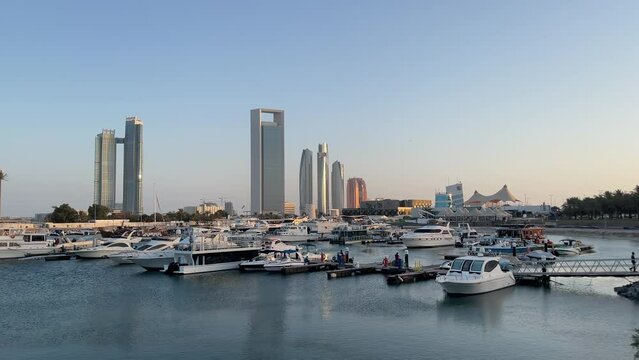 View of Abu Dhabi city corniche and beach - Adnoc headquarters and Nation towers - boats and marina
