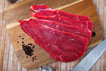 Slicing juicy raw beef fillet on the table.