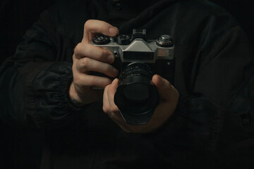 man holding Retro film photo camera isolated on black background soviet