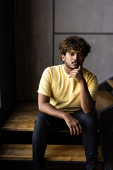 Low angle indian man sitting on steps at home