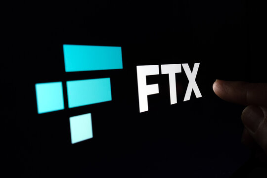 Finger pointing at blurred FTX Cryptocurrency Exchange company logo on  dark display. Selective focus. Concept. Stafford, United Kindom, November 13, 2022.