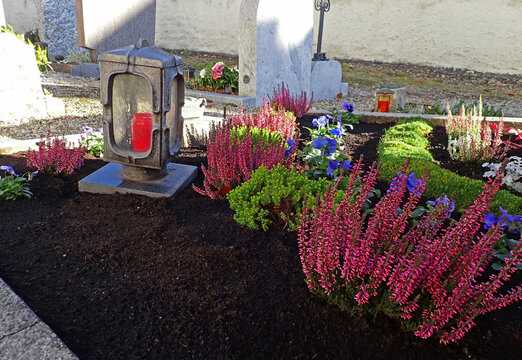 Sch&ouml;n geschm&uuml;ckte Gr&auml;ber auf einem Friedhof an Allerheiligen im Herbst

