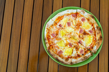 Delicious pizza with pineapple and ham on wooden table, top view