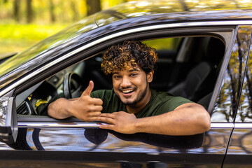 Young asian man showing thumb up in his car.