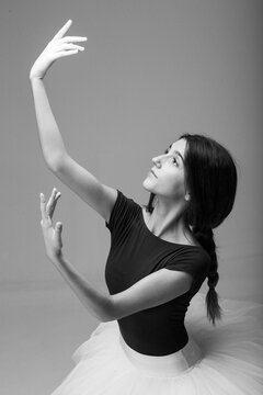 Adult caucasian ballerina dancing in a photography studio alone.Black and white pictures.