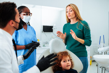 Woman talking to dentist about child.