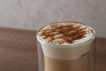 Caramel cappuccino with frothed milk sprinkled with chocolate
