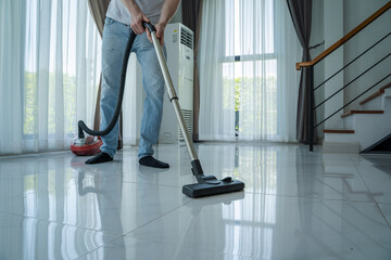 Fototapeta premium Man does housework with a vacuum cleaner,Vacuuming and Cleaning the House.