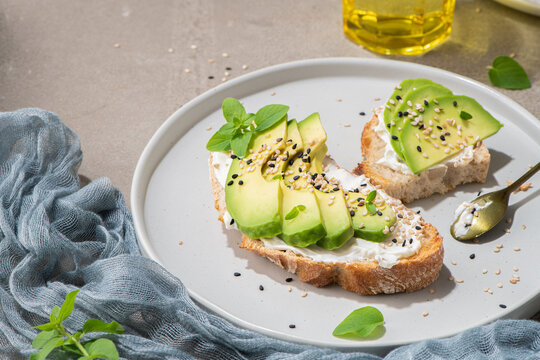 Healthy toast with avocado cream cheese and wheat bread on a plate. Delicious snacks and avocado sandwiches. Food composition, tasty Italian meal.