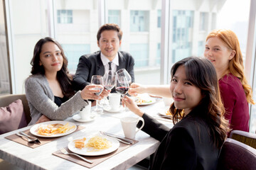 Happiness team young business people in party celebrate success holding glass of wine cheer together at restaurant luxury, friendly and social colleague, meet friend and community concept.