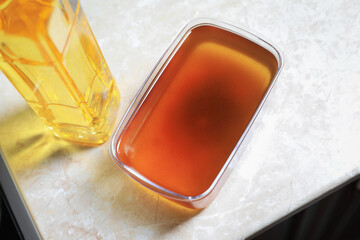 New and used cooking oil on beige marble table, above view