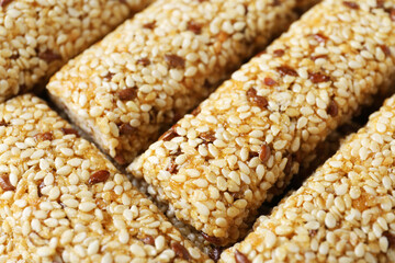 Tasty sesame seed bars as background, closeup
