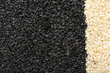 Black and white sesame seeds as background, top view