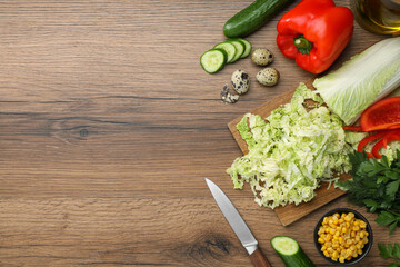 Chinese cabbage and different products on wooden table, flat lay. Space for text