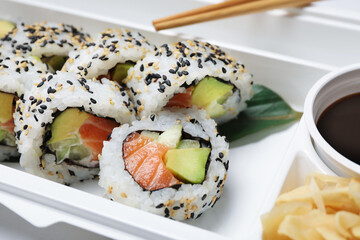Food delivery. Delicious sushi rolls in plastic container, closeup