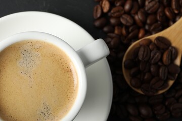 Cup of aromatic coffee and beans on grey table, flat lay. Space for text