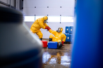 Accident in chemical factory, slippery floor, spilled chemicals. Worker in protection hazmat suit...