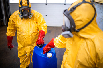Industry workers in protective suits handling acids and aggressive substances in chemicals...