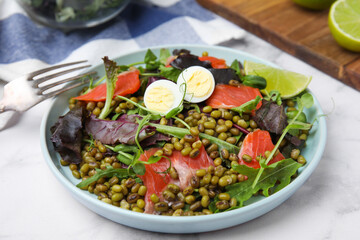 Plate of salad with mung beans on white marble table, closeup