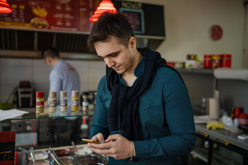 Portrait of one man young adult caucasian male standing in fast food restaurant waiting for the...