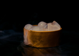 Ice in a golden box with smoke, colorful smoke, blue smoke, gray smoke, ice in syrup, delicious ice. space picture on dark background