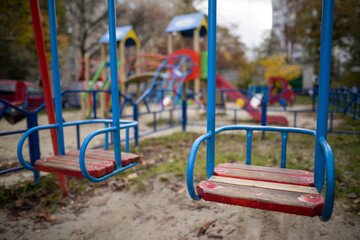 a lonely empty swing on a playground without people.