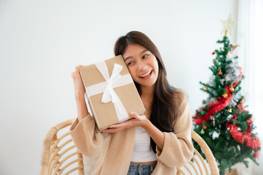 Young asian woman happy and smile while opening gift box. Happy new year, Thanksgiving, Merry Christmas