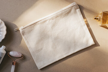 Blank canvas makeup bag mockup on a beige, cream background.