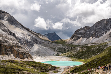 Unrecognizable tourists at beautiful landscapes of Milk Lake in Yading Nature Reserve,The Yading Nature Reserve in the Kham region of Sichuan is one of the most beautiful places on the Tibetan Plateau